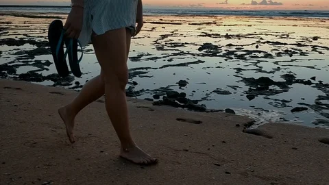 Track shot on the woman's legs while walking in the beach at sunset. Stock Footage 111977945