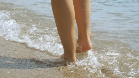 Track shot on the woman's legs while walking in the beach Stock Footage 112400542