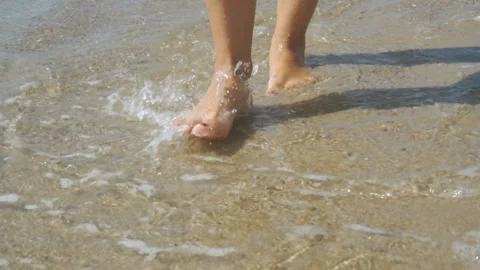 Track shot on the woman's legs while walking in the beach Stock Footage 112401974