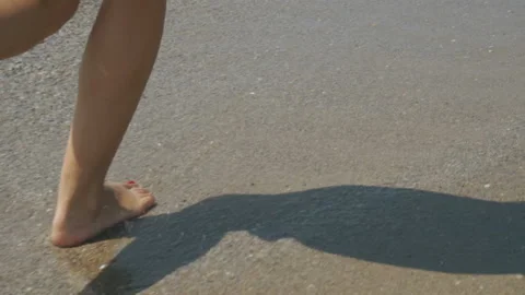 Track shot on the woman's legs while walking in the beach Stock Footage 112404706