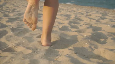 Track shot on the woman's legs while walking in the beach Stock Footage 112410608