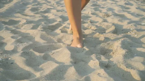 Track shot on the woman's legs while walking in the beach Stock Footage 112411220