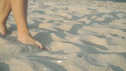 Track shot on the woman's legs while walking in the beach Stock Footage 112411672