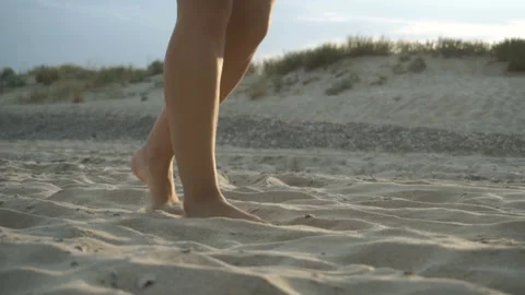 Track shot on the woman's legs while walking in the beach Stock Footage 112412096