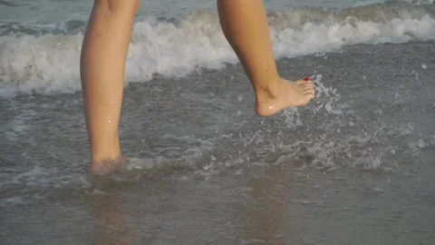 Track shot on the woman's legs while walking in the beach Stock Footage 112412974