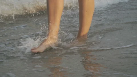 Track shot on the woman's legs while walking in the beach Stock Footage 112413366