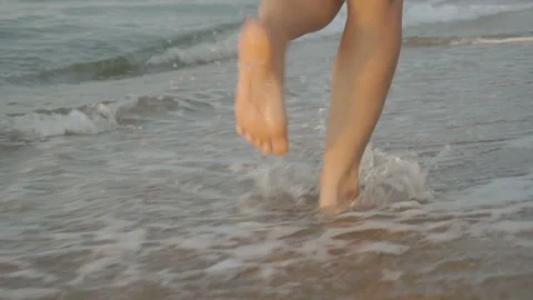 Track shot on the woman's legs while walking in the beach Stock Footage 112416520