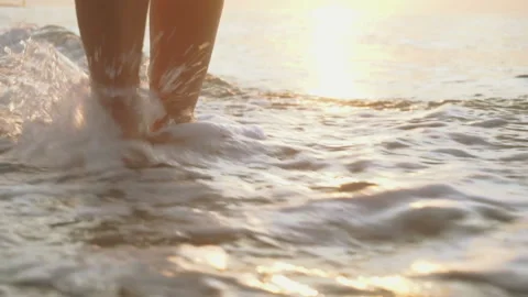 Track shot on the woman's legs while walking in the beach Stock Footage 112416913