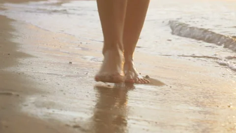 Track shot on the woman's legs while walking in the beach Stock Footage 112417342