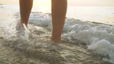 Track shot on the woman's legs while walking in the beach Stock Footage 112418190