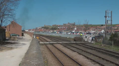 Track side view as steam train leaves Whitby station for North Yorkshire Moors Stock Footage 3576988