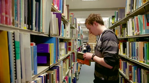 Track in of a Student Looking through Library Books Stock Footage 61638614