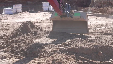 Tracked excavator bucket digging, scooping and lifting soil ground at an urba Stock Footage 335529320