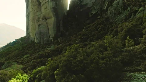 Tracking aerial shot rays of bright sun looking out through high mountains Stock Footage 95503065