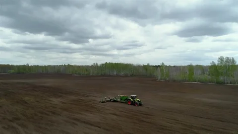 Tracking Aerial Shot of Tractor Working Farm Cultivating the Land in Countryside Stock Footage 127978198