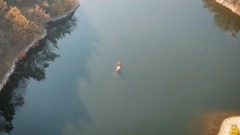Tracking aerial shot of two men paddling canoe Stock Footage 119231909