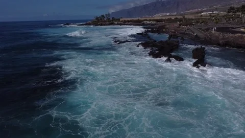 Tracking aerial shot of waves crashing over the Atlantic coast in Tenerife Stock Footage 240655166