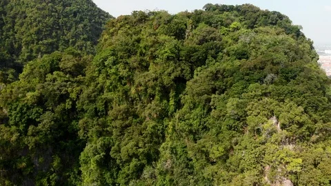 A tracking aerial view of a limestone hill revealing a town Stock Footage 116539072