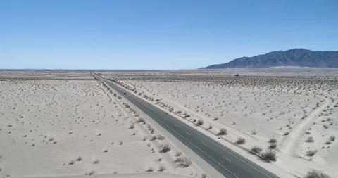 Tracking along with cyclist through sandy terrain with mountains drone aerial 4K Stock Footage 111308853