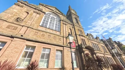 Tracking along front of old building town hall uk sunny day Stock Footage 289114730