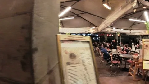 Tracking along a string of outdoor French cafes full of evening diners Vídeo Stock 304934017