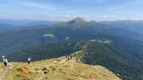 Tracking back view of trekking tourists going down a steep sloppy path Video stock 250488337