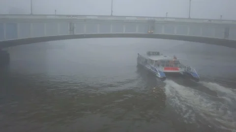 Tracking Behind Clipper Passing Under Bridgr on Foggy River Thames 库存影片 103463985