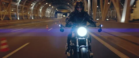 TRACKING Biker riding his custom built motorcycle through city at night Stock Footage 202093139