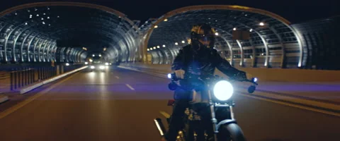 TRACKING Biker riding his custom built motorcycle through city at night Stock Footage 202095263