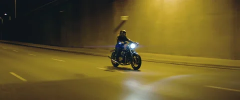 TRACKING Biker riding his custom built motorcycle through city at night Stock Footage 202095633