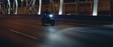 TRACKING Biker riding his custom built motorcycle through city at night Stock Footage 202095805