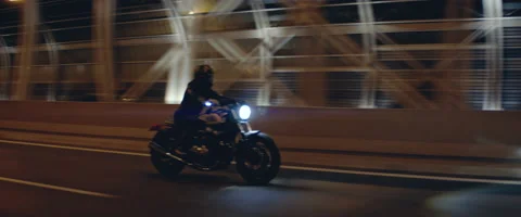 TRACKING Biker riding his custom built motorcycle through city at night Stock Footage 202097139