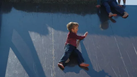 Tracking with boy sliding into corn pile while waving to big brother Stock Footage 202233487