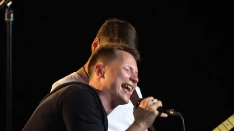The tracking camera behind the rock band singer that sings into the microphone Stock Footage