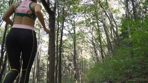 Tracking camera of girl running in the forest, jumping off tree trunks on hard Stock Footage 117687965
