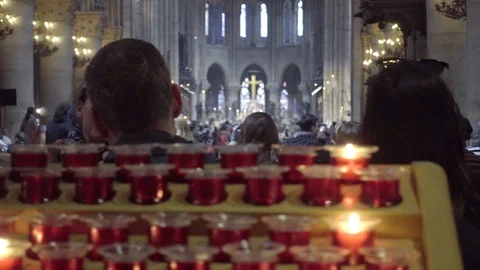 Tracking candles inside Notre Dame Cathedral - interior - people talking Paris Stock Footage 94429328