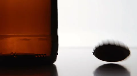 TRACKING: The cap falls near a brown bottle Stock Footage 53315580
