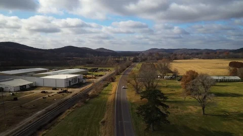Tracking Car Driving Along Small Town Country Road Drone Shot 4K Stock Footage 121104016