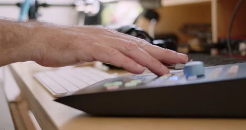 Tracking Close-up of fingers gently moving fader on audio mixing console Stock Footage 234761279