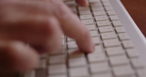 Tracking Close-up of a man's fingers typing on a computer keyboard Stock Footage 234759567