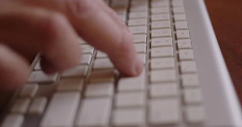 Tracking Close-up of man's fingers typing on a computer keyboard Stock Footage 234759915