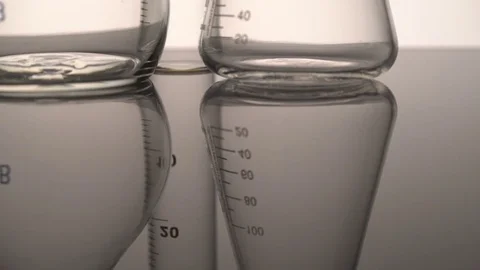 Tracking close-up shot of empty chemical glass flasks and test tube reflecting Stock Footage 75939921