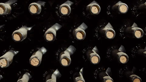 Tracking Close Shot of Old Aged Stacked Wine Bottles in a Cellar Stock Footage 254821941