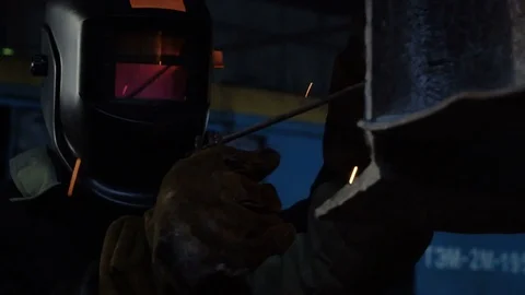 Tracking close-up of welder in the protactive mask welding the metal parts of Video stock 75068429
