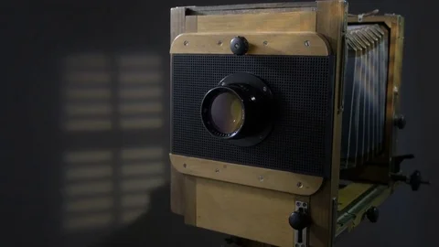 Tracking close up zoom out shot of old vintage wooden photo camera lighting by Video stock 75896035