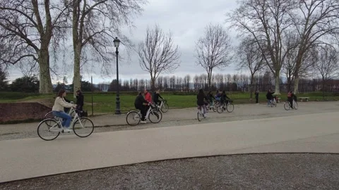 Tracking cyclists riding along the Renaissance walls of Lucca Historic Center Stock Footage 341841107
