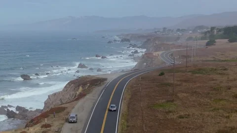 Tracking Dolly of Car Driving PCH Coast Over Beach and Cliffs Stock Footage 295265792