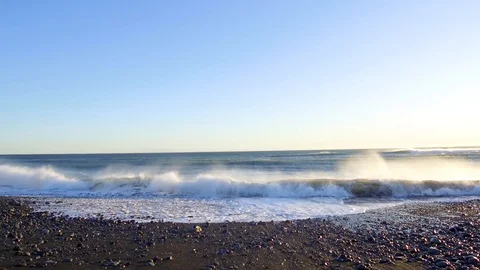 Tracking dolly shot camera moves alongside sea waves in black sand beach Stock Footage 95196558