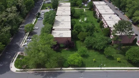 Tracking drone footage of an partment complex surrounded by trees Stock Footage 341274376