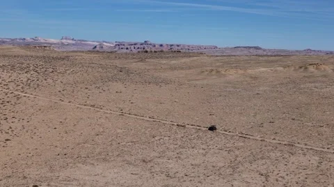 Tracking Drone Shot of Black UTV Vehicle Moving on Desert Road in Landscape of Stock Footage 320382828
